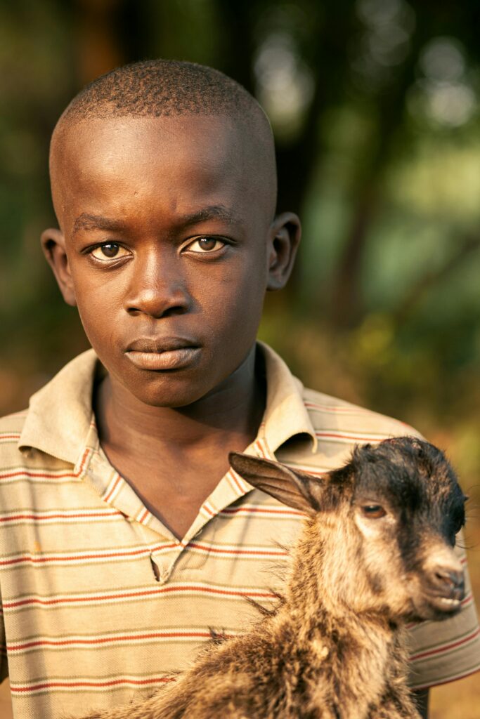 Photo by Kh-ali-l i: https://www.pexels.com/photo/concentrated-black-teen-boy-hugging-goat-and-looking-at-camera-6672097/